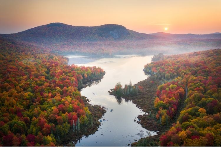 OPENER - Seemingly still waters wind through colorful canopies displaying warm autumn hues on a hazy September morning.
