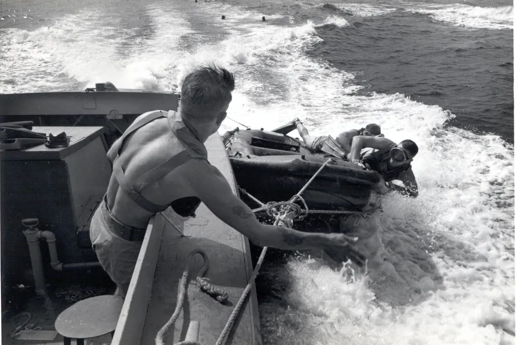 UDT members deploying from a speeding landing craft