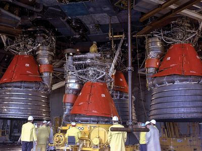 In April 1965, engineers install five 1.5-million-pound-thrust F-1 rocket engines on a Saturn V stage for a static test.