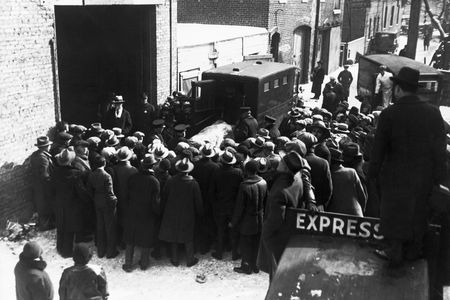 Onlookers watch as police remove the bodies of the victims of an execution-style murder from the scene at 2122 North Clark Street in Chicago. 