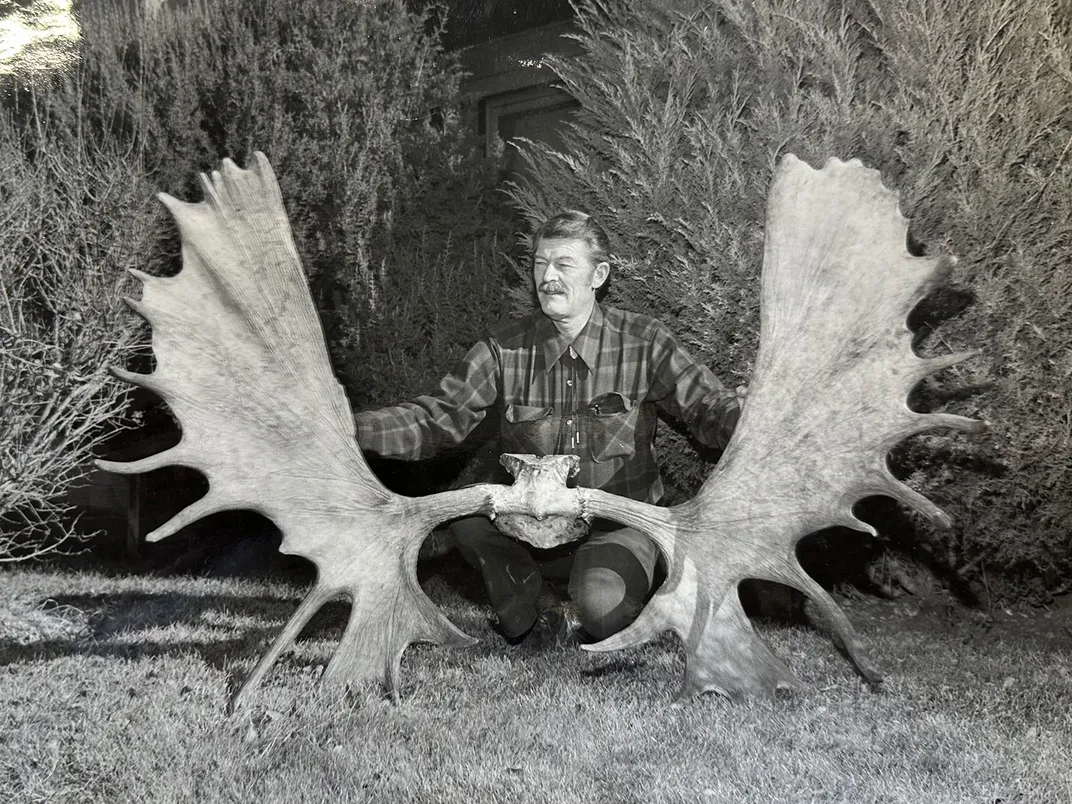 Man Poses With Moose Antlers