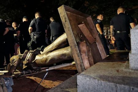 Police stand guard around the Confederate statue Silent Sam after it was toppled by protestors at the University of North Carolina at Chapel Hill. 