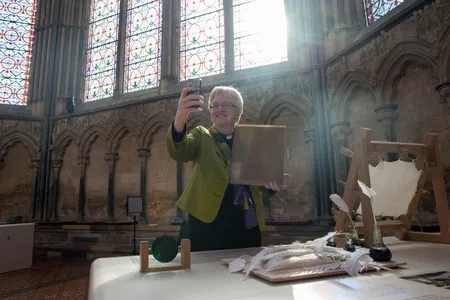 The Very Reverend June Osborne, Dean of Salisbury, takes a selfie with a laminated copy of the 1215 Magna Carta that is on display at Salisbury Cathedral.
