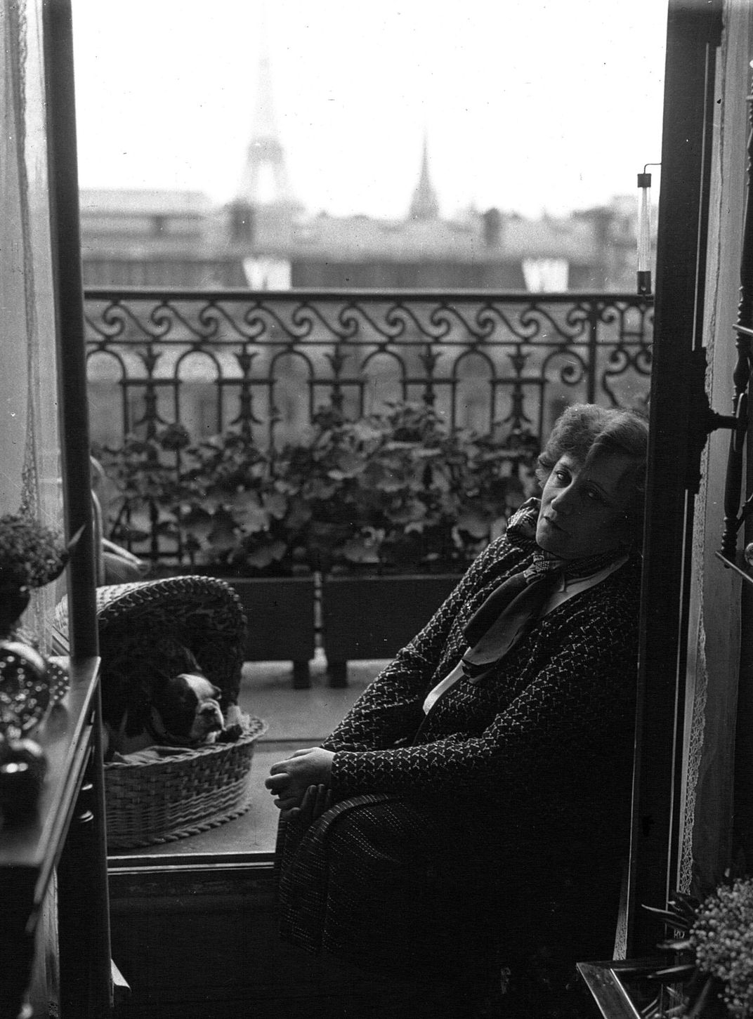 Colette seated on her balcony, with the Eiffel Tower visible in the background, in 1932