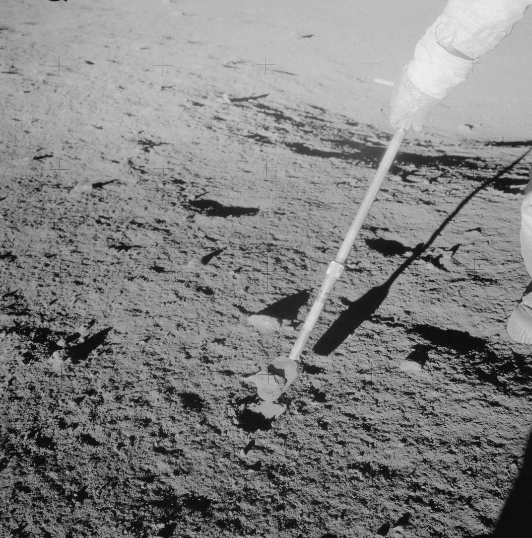 In this photo from the surface of the moon, Apollo 12 astronaut Charles “Pete” Conrad Jr. holds a scoop for collecting samples. Somehow, the rock Conrad is seen collecting seems to have gotten dropped and never made it back to Earth.