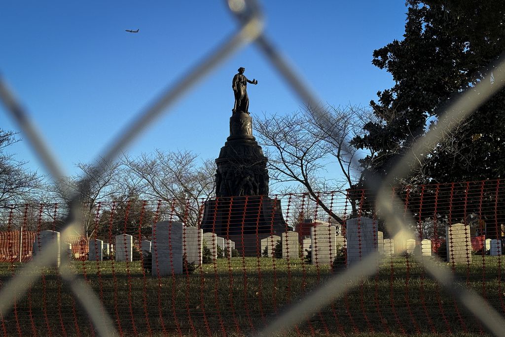 Fencing in front of a tall statue