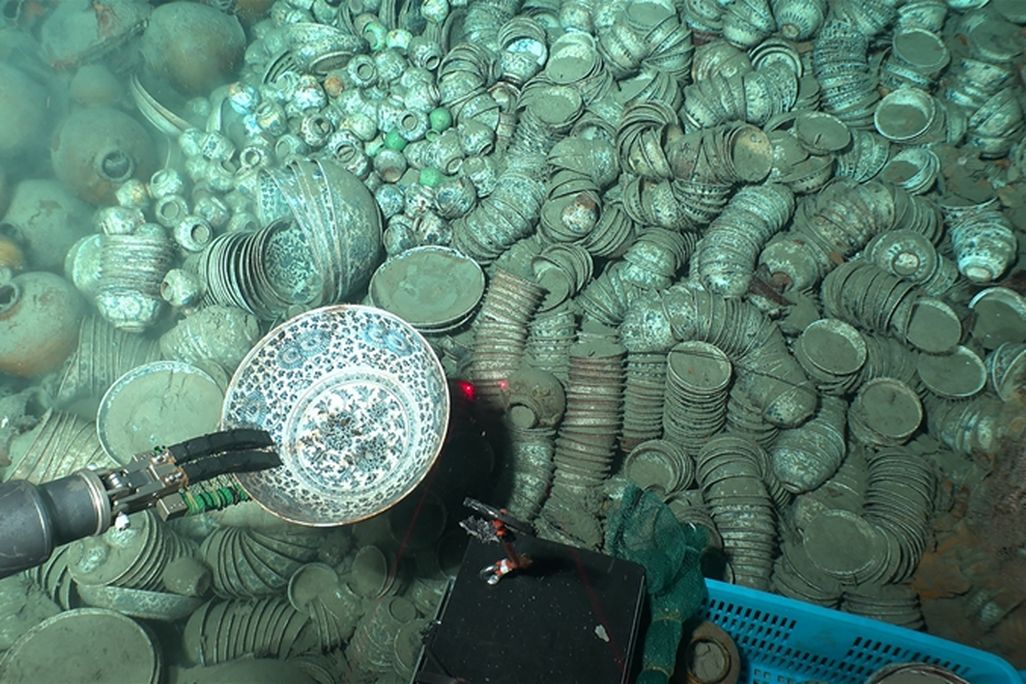 Robot arm grabbing a piece of pottery underwater