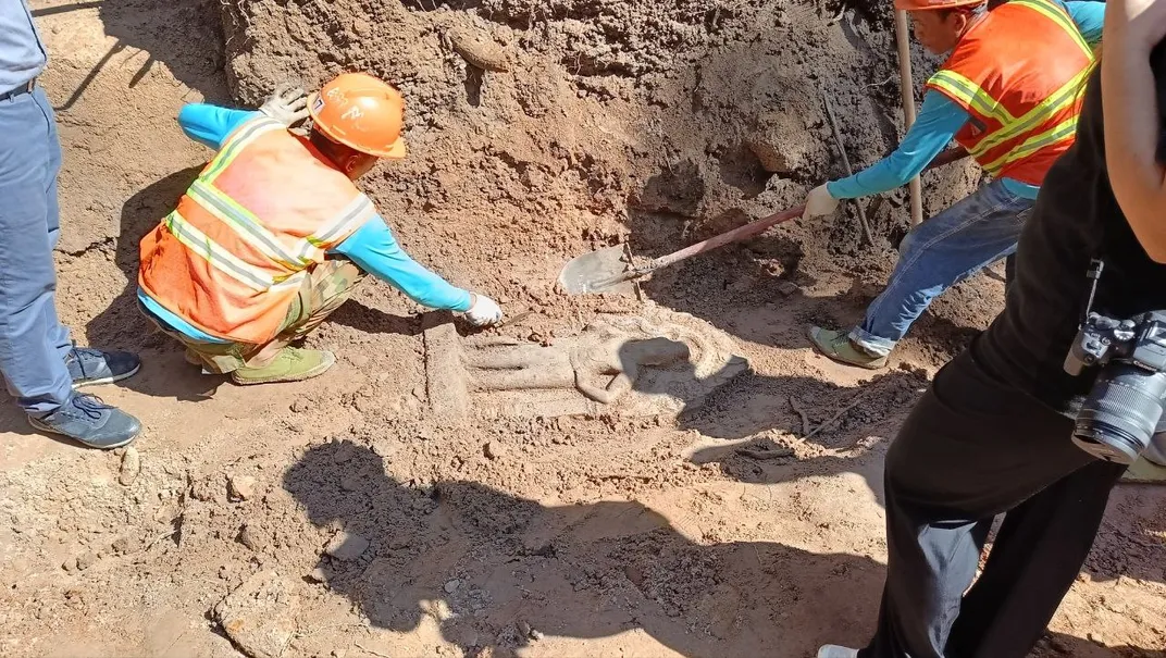 Archaeologists unearthing one of the door guardian statues