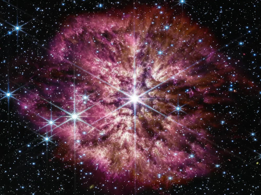 Purple and pink nebular surrounding bright white star against dark background