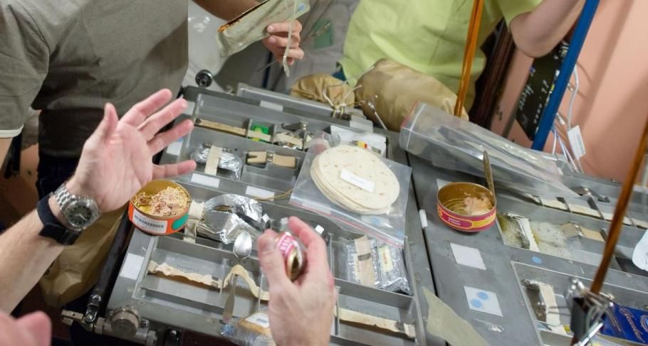 Eating canned food in space. (NASA)