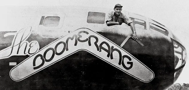 Carl Schahrer, commander of the B-29 Boomerang, shows off the talisman, on which his crew carved their missions.