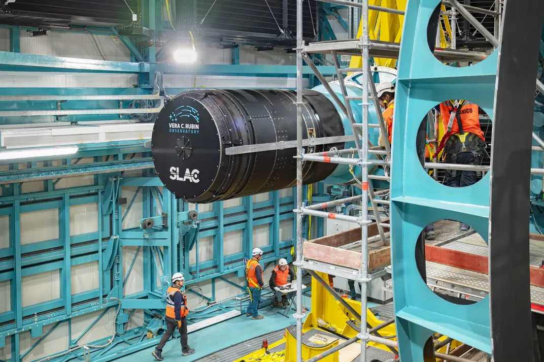 a big lens being installed surrounded by blue scaffolding