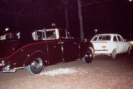 The aftermath of Ian Ball&#39;s attempt to kidnap Princess Anne. Ball&#39;s white Ford Escort is parked blocking the path of the princess&#39; limousine.