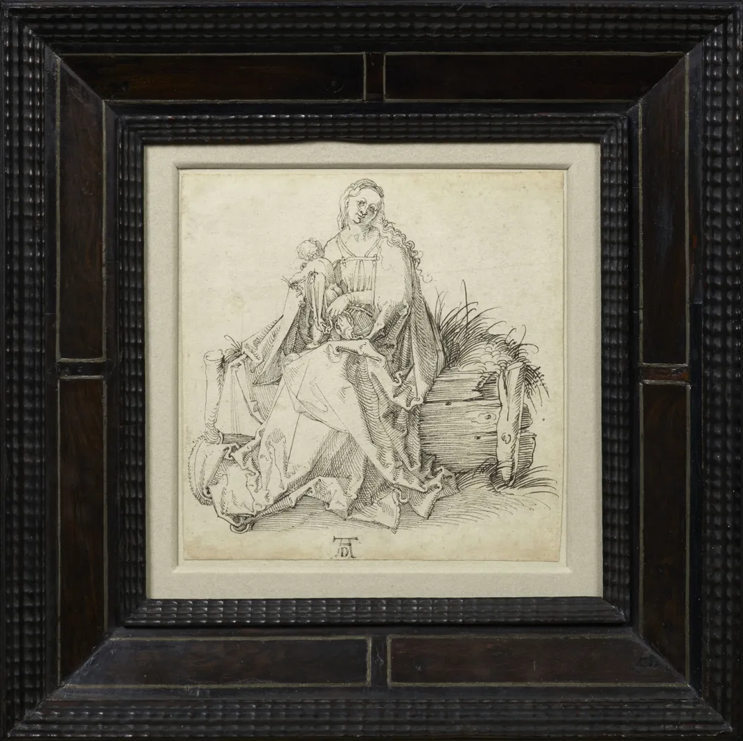 A thick black frame holds a yellowed piece of paper with an ink sketch of the Virgin holding a baby Jesus