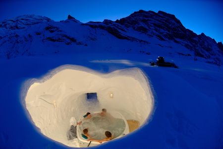A group enjoys an igloo hot tub at Iglu-dorf.