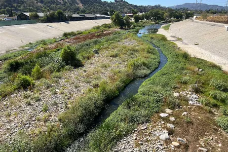 A view of the soft-bottomed Los Angeles River below the 400-foot-long Taylor Yard Bridge in Elysian Valley. The newest Taylor Yard parcel, currently fenced off as it undergoes toxic remediation, can be seen on the far right.