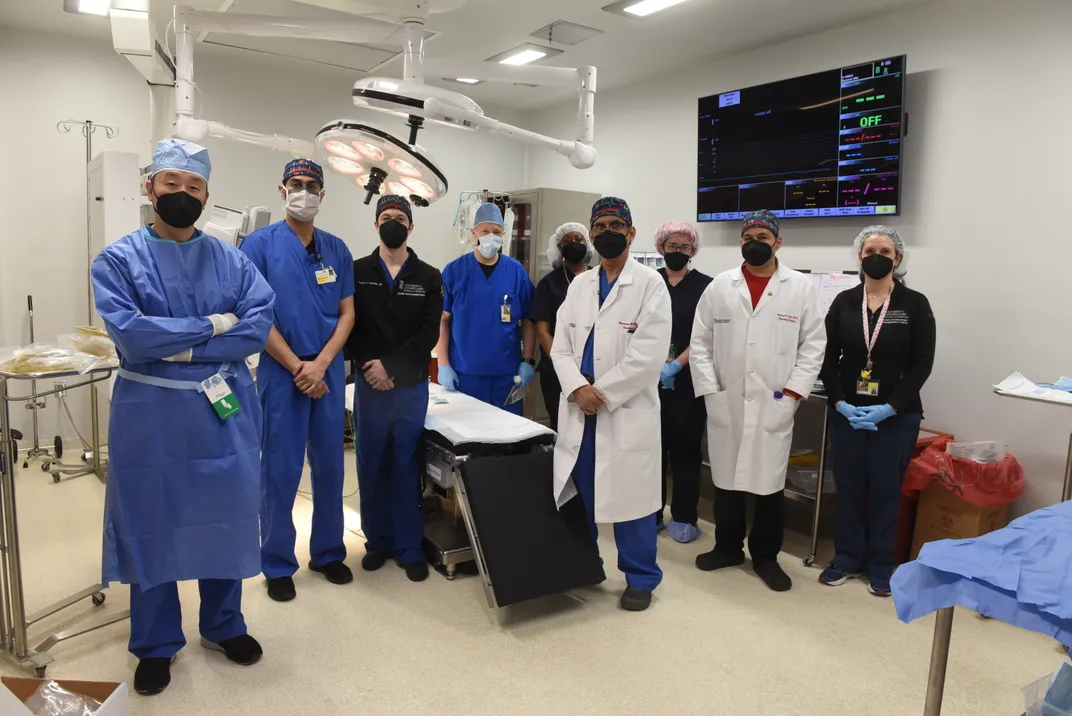 A team of medical professionals responsible for the surgery posing for a photo in the OR