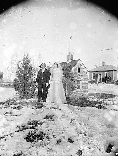 Newlyweds in front of small brick church