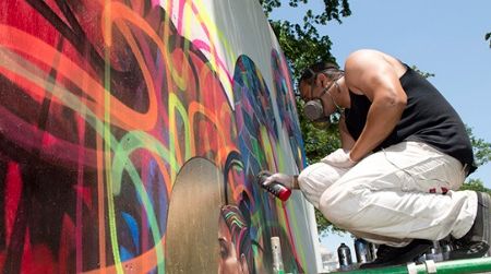 An artist works on a mural installation in the “Citified” program.