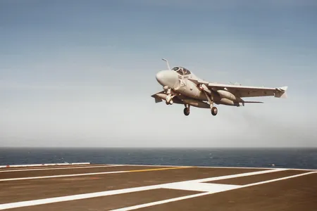 Intruder NE 510, with speed brakes deployed, lands on the USS Ranger.