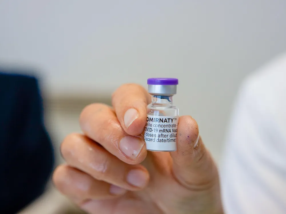 A hand holding the vial of Pfizer/BionTech's covid-19 vaccine