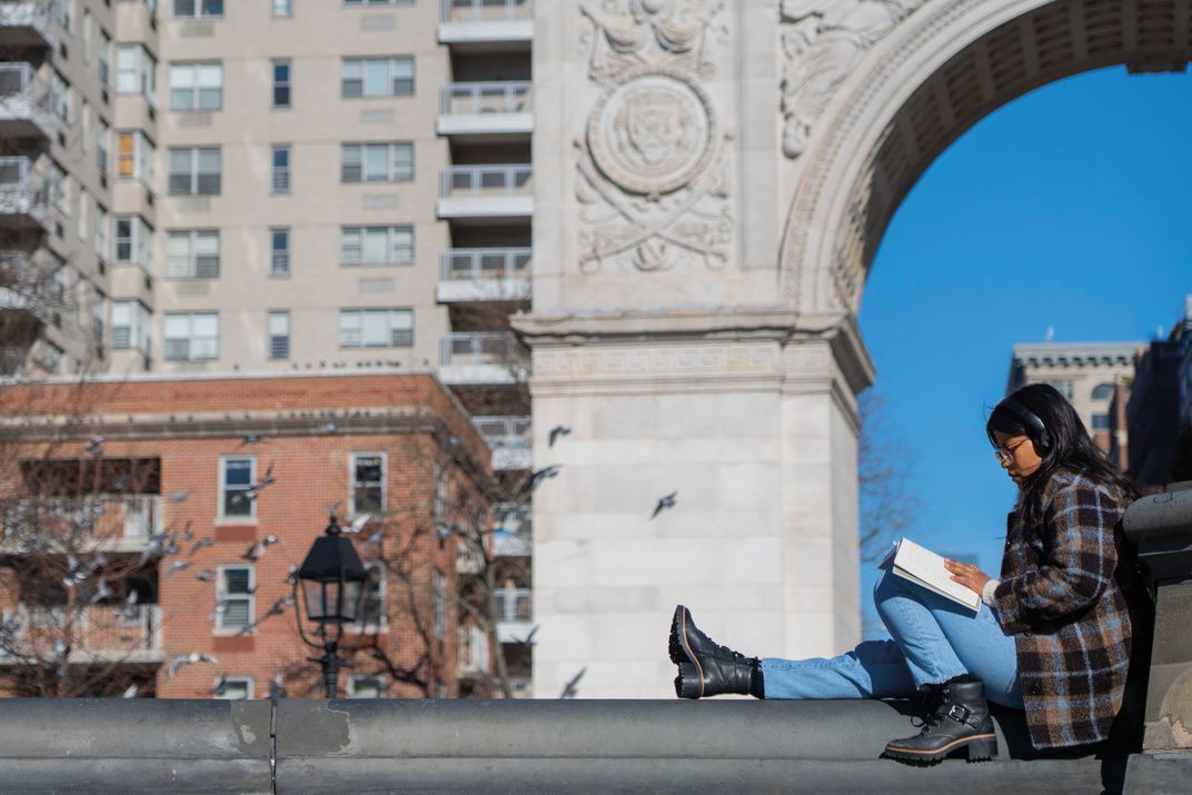 a person is reading in Washington Square Park in New York City