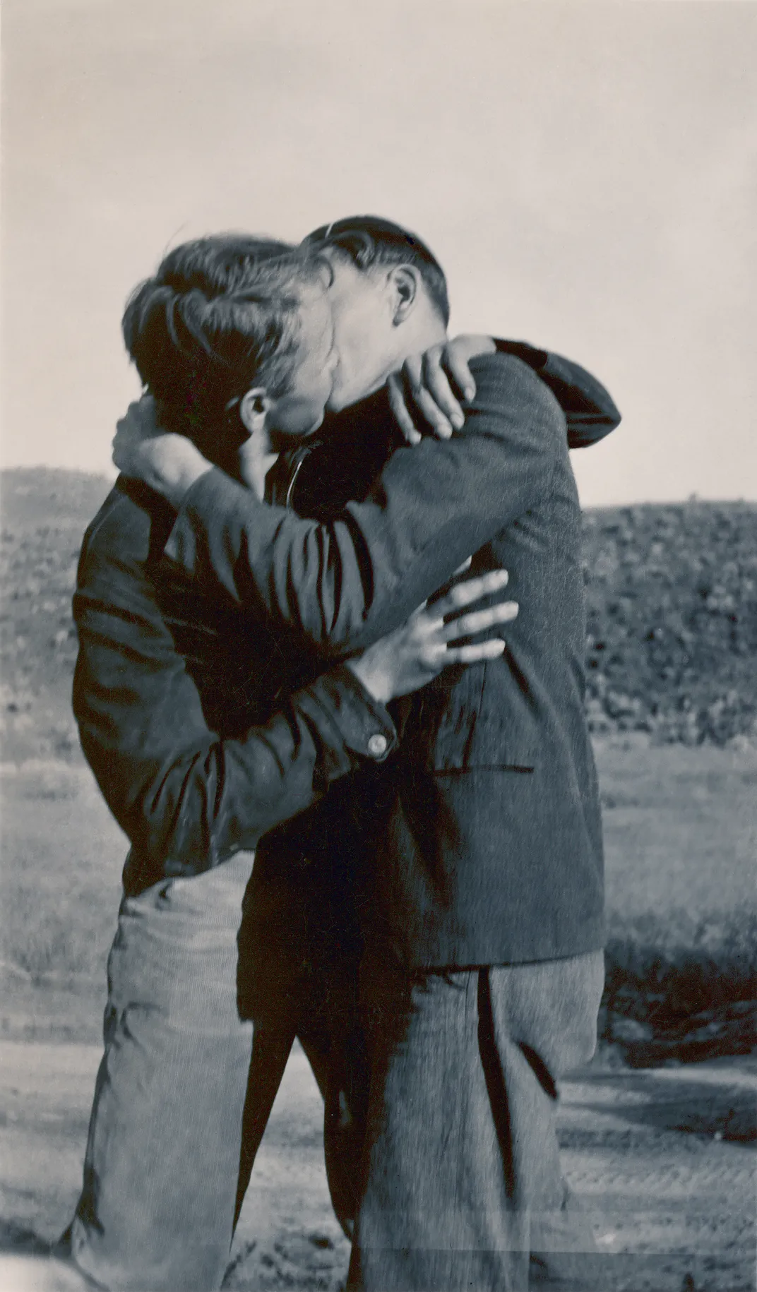 Black and white photo of two men kissing