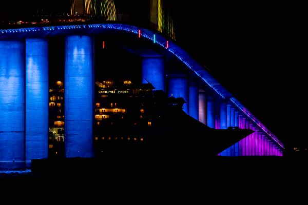 Cruise ship sails under Skyway Bridge’s while illuminated light display changes colors thumbnail