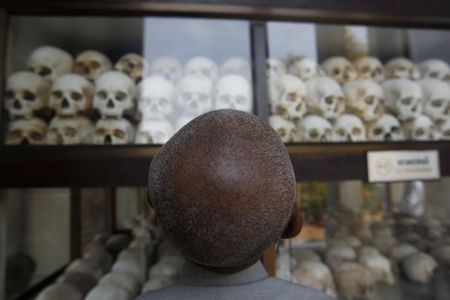 A man looks at skulls and bones of more than 8,000 victims of the Khmer Rouge regime at Choeung Ek, a "Killing Fields" site located on the outskirts of Phnom Penh April 17, 2014.