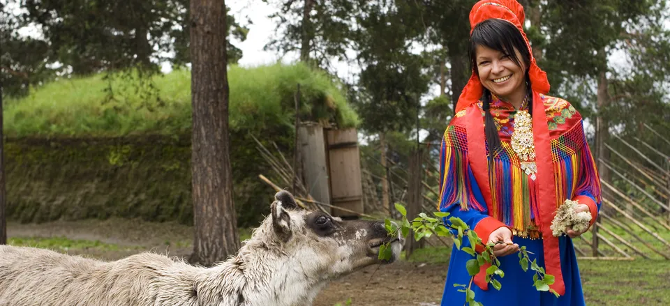  Woman in traditional Sami dress with reindeer. Credit: Norway Tourism Bureau