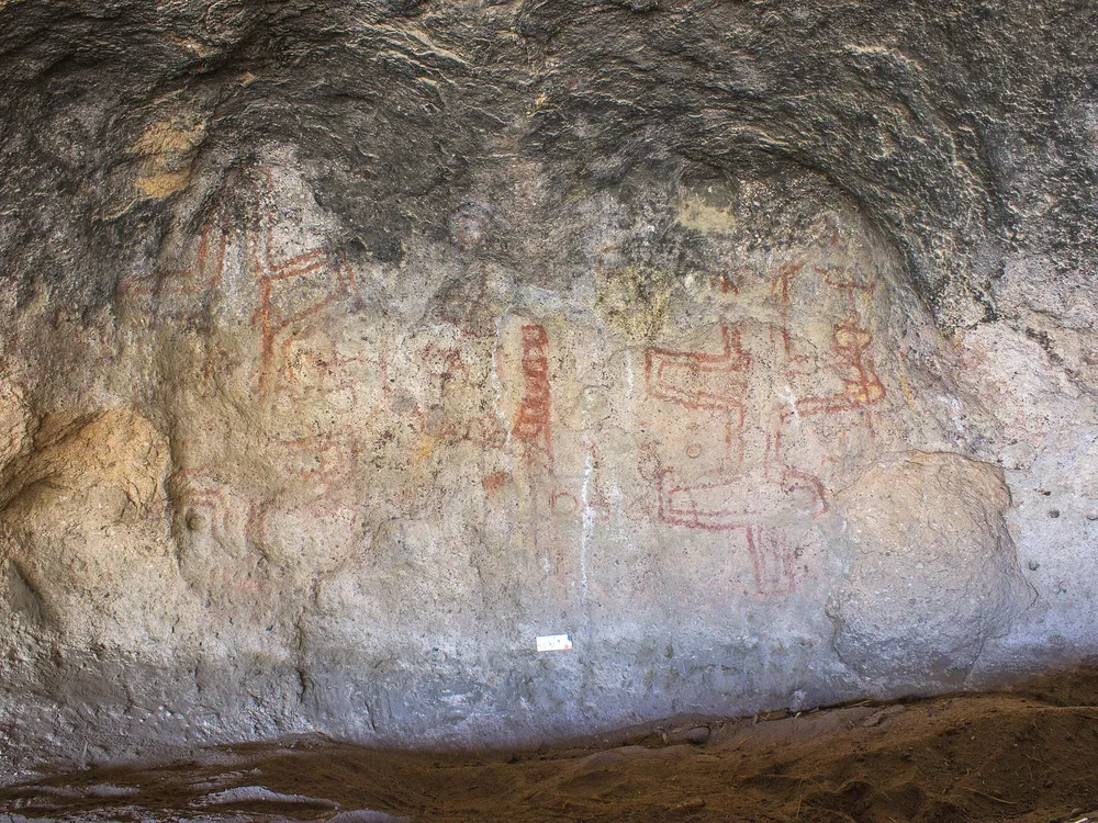 Red geometric drawings on a cave wall