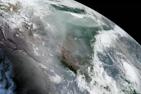 A satellite image of North America taken on August 25, 2020. Smoke from wildfires can be seen rising from California and Hurricane Laura can be seen heading toward Louisiana and eastern Texas as the remnants of Marco swirl over the Southeast.