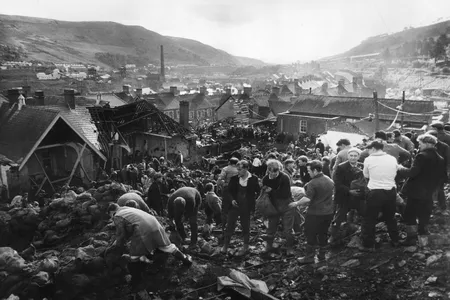 Helpers fill sandbags on the tip above the shattered Pantglas Junior School to divert a spring and avert the risk of further landslides at Aberfan, South Wales.
