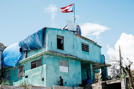 A home on the storm-battered southeastern coast. The words on the sign, “Yo voy a ti PR,” translate roughly to “I’m rooting for you, Puerto Rico!”