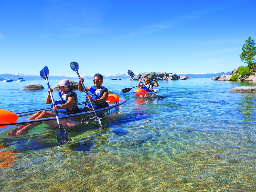People kayaking on clear lake waters