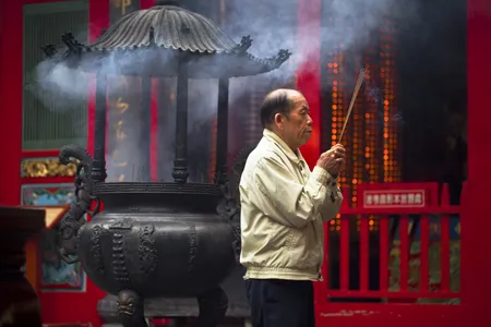 A worshiper burns incense.