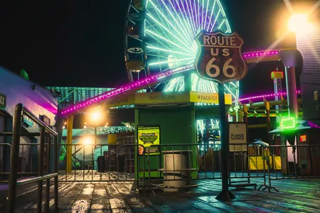 Neon lights illuminate an oddly empty Santa Monica Pier at night.