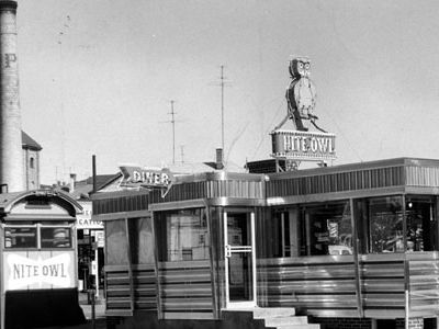 This 1956 photograph was taken during the short time that two Nite Owls sat cheek-by-jowl in Fall River, MA. Soon the old lunch wagon was carted away and demolished, replaced by the gleaming diner.