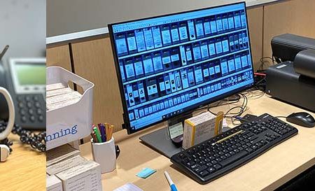 Color image of white erasers in blue and white sleeves in front of a green and white mug full of pencils with a phone and jar of pens in the background next to a color image of a computer and microfilm scanner with images of scans on the screen.