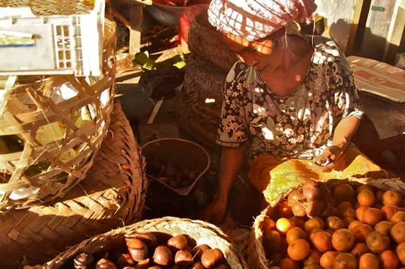 Monsaro, a Balinese salak vendor, waits for customers amidst her fruity fares.