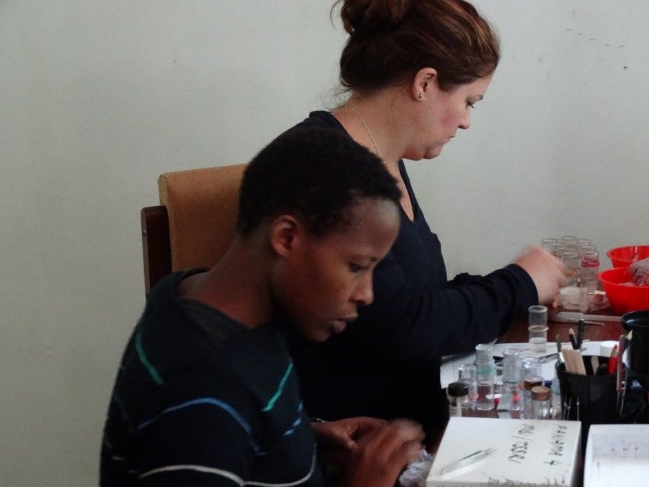 Two people sitting at a table with lab equipment.