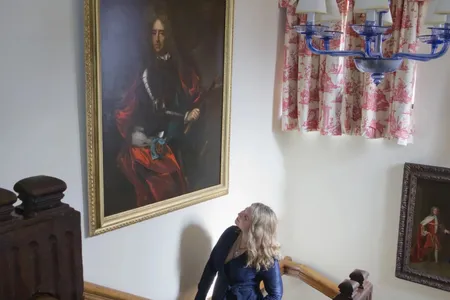 Curator Katherine Carter with the restored Marlborough portrait in Chartwell's main staircase