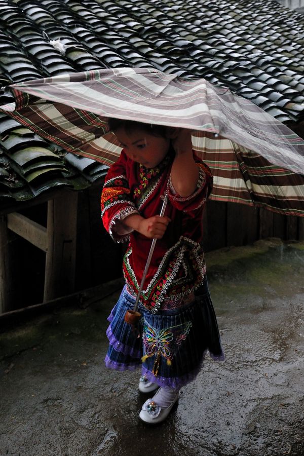 Miao tribe girl walking in the rain. thumbnail