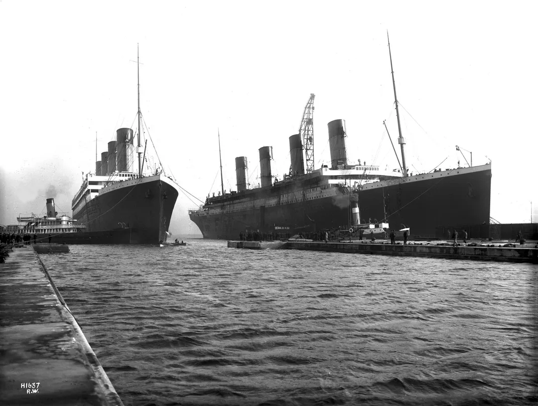 The Olympic (left) is led into dry dock in Belfast for repairs on the morning of March 2, 1912, after throwing a propeller blade. The Titanic (right) is moored at the fitting-out wharf.