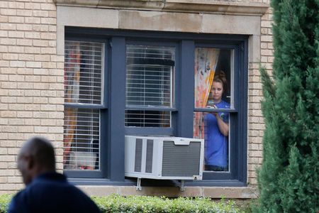 A Dallas resident in a neighborhood where one of the persons diagnosed with Ebola lives peers out of her window. 