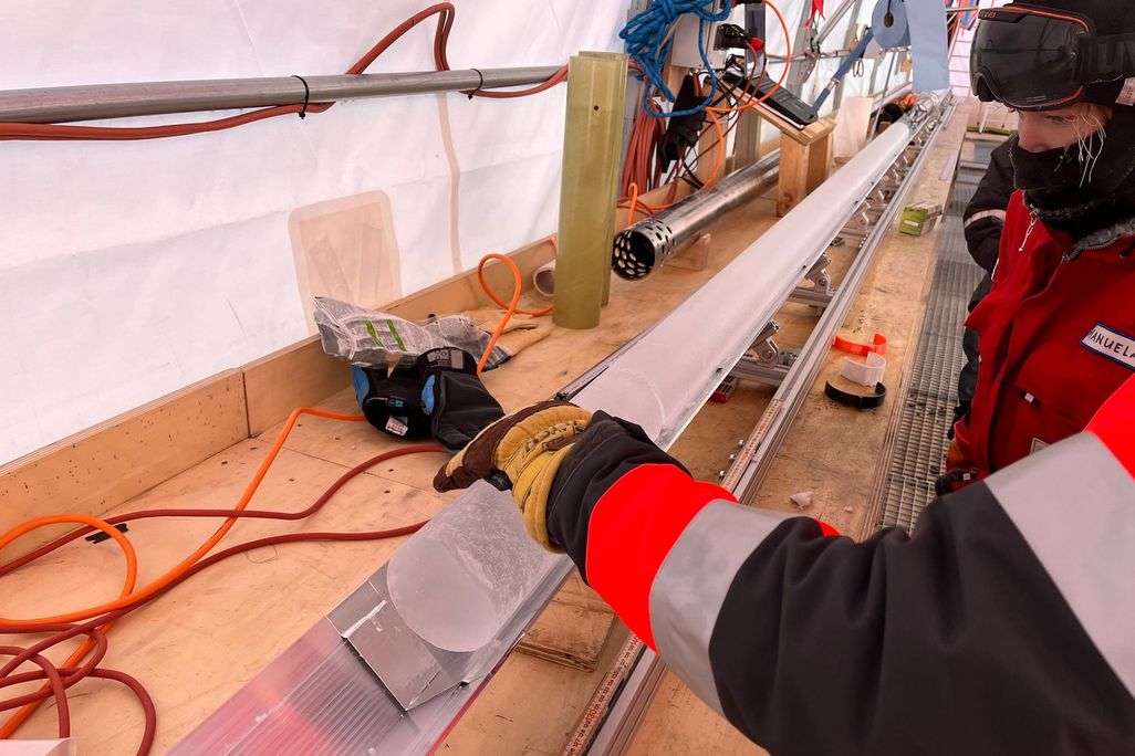 Scientists looking at a column of ice on a table