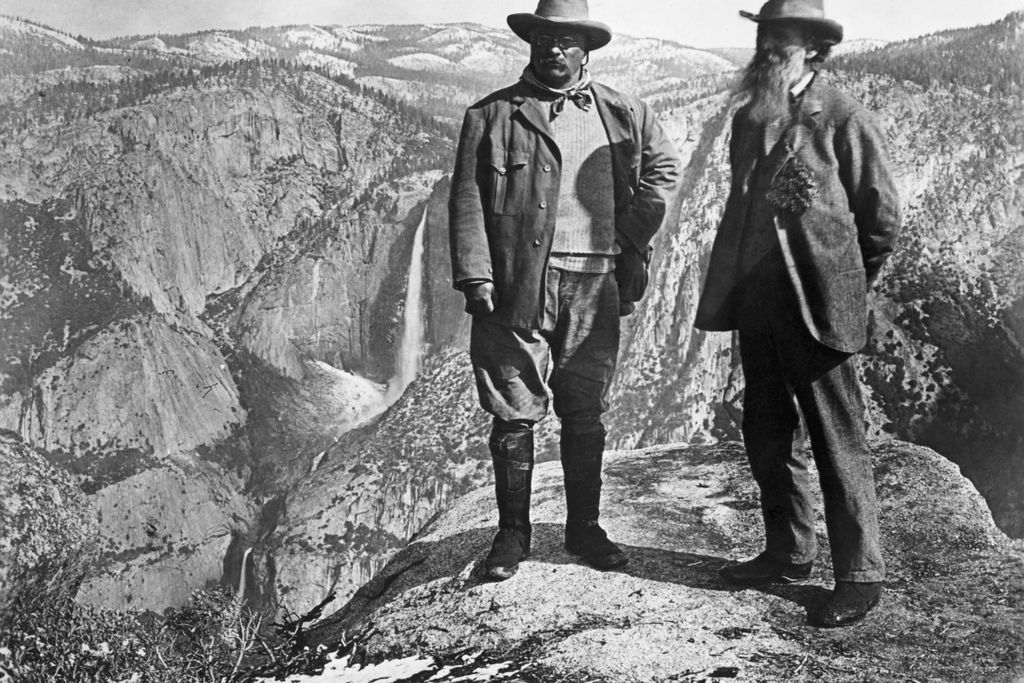 Theodore Roosevelt stands with naturalist John Muir on Glacier Point, above Yosemite Valley, California, USA.