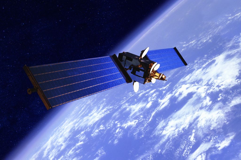 a satellite with solar panels above Earth