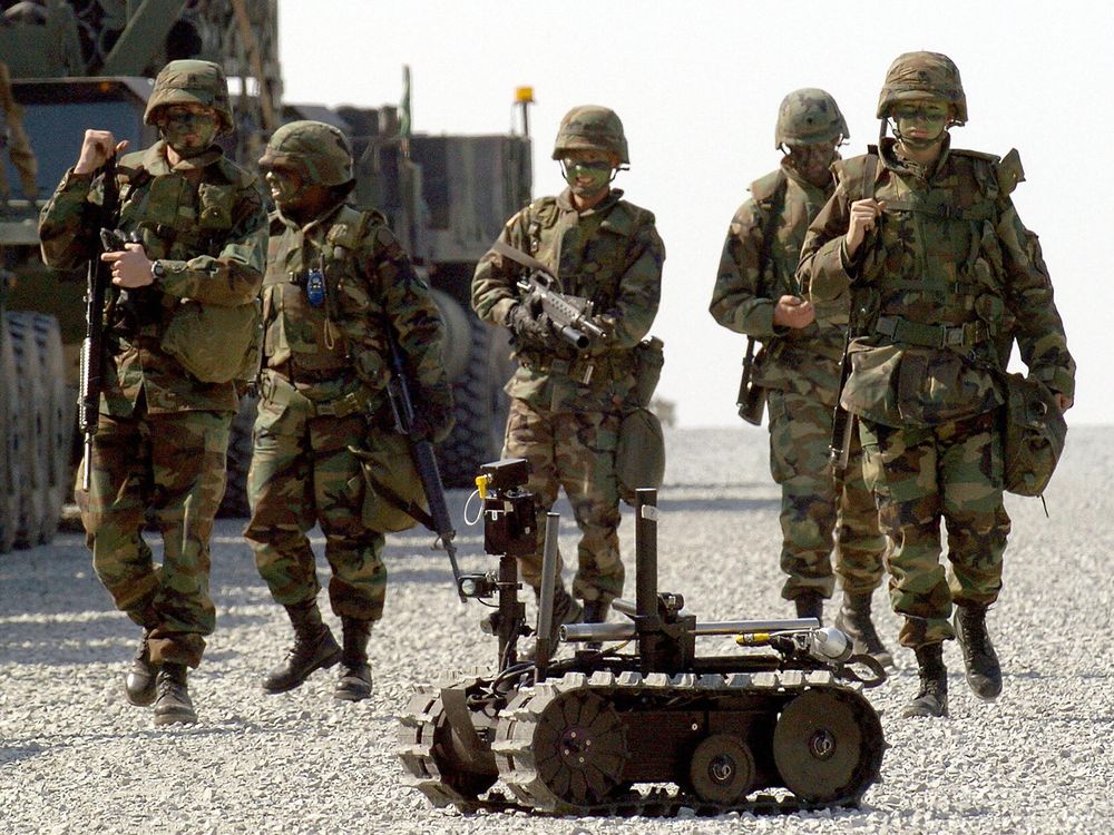 US soldiers walk behind a military robot during military exercises by US and South Korea troops