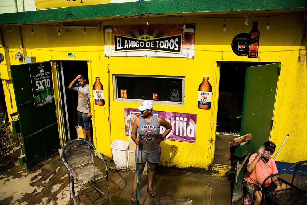 Workers clean a business that flooded in Toa Baja, on Puerto Rico’s northern coast.